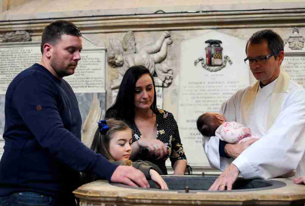 A baby being baptised in the font at Bath Abbey