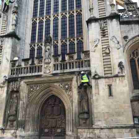 Abseiling stonemasons from Sally Strachey History Conservation (SSHC) check Bath Abbey's West front