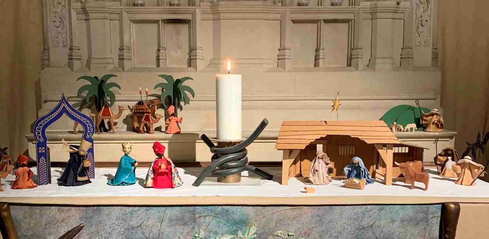 A nativity scene with a candle and wooden figures