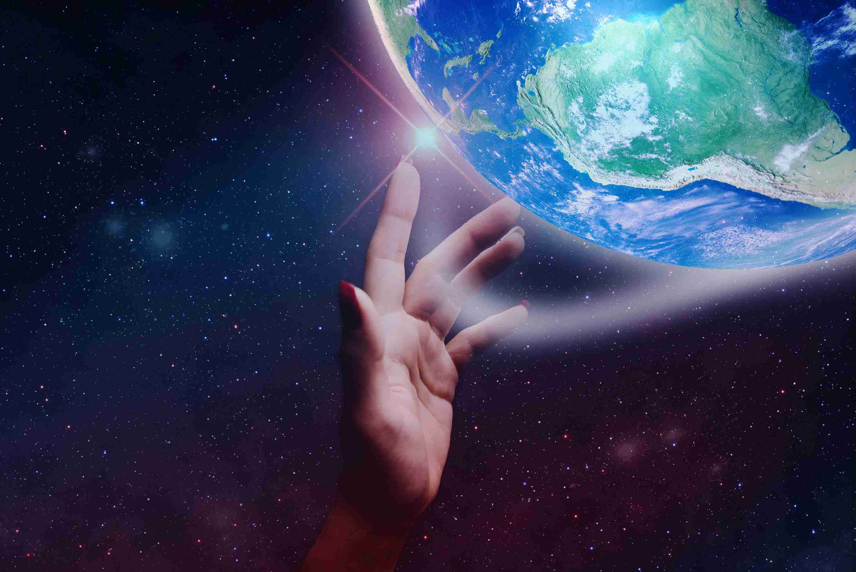 Hand reaching through space for the Earth