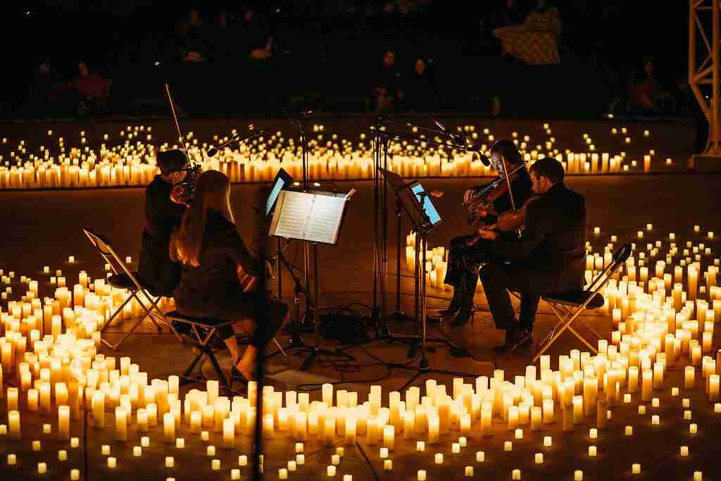 Musicians playing surrounded by lit candles