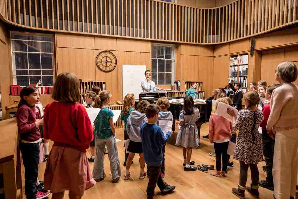 Young children perform in Bath Abbey's double storey oak-lined Song School