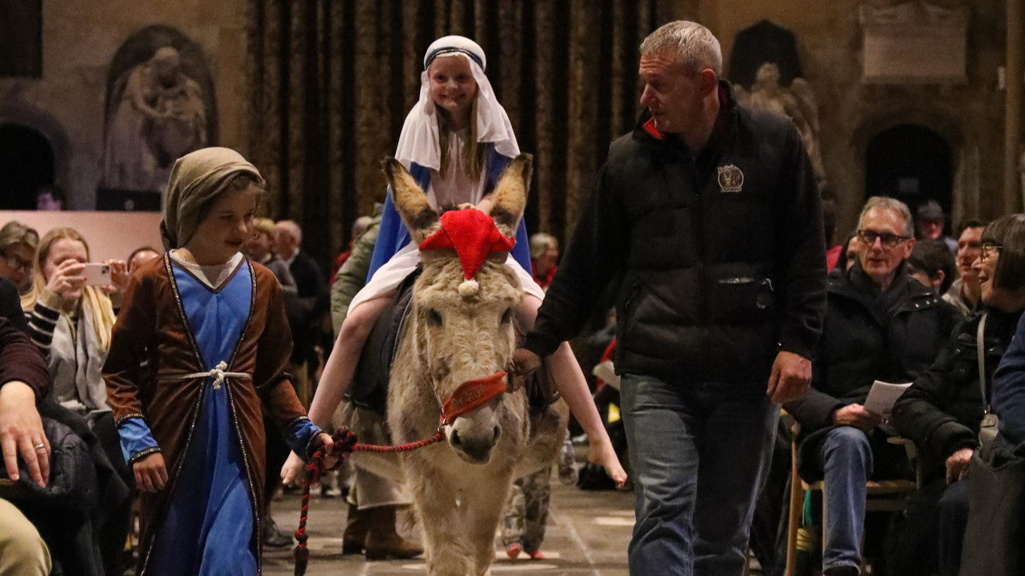 Child dressed as Mary riding Dermot the Donkey, accompanied by a child dressed as Joseph