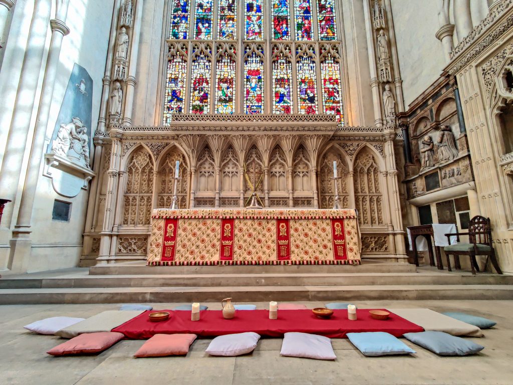 Altar at Bath Abbey with a mat and cushions laid out for the Stations of the Cross Last Supper