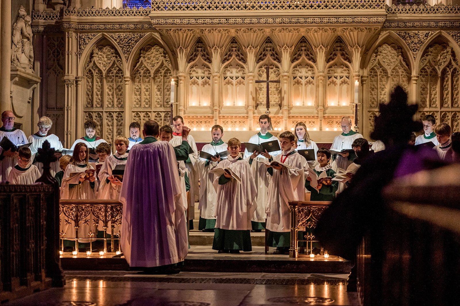 Robed choir boys perform in front of the altar at Bath Abbey