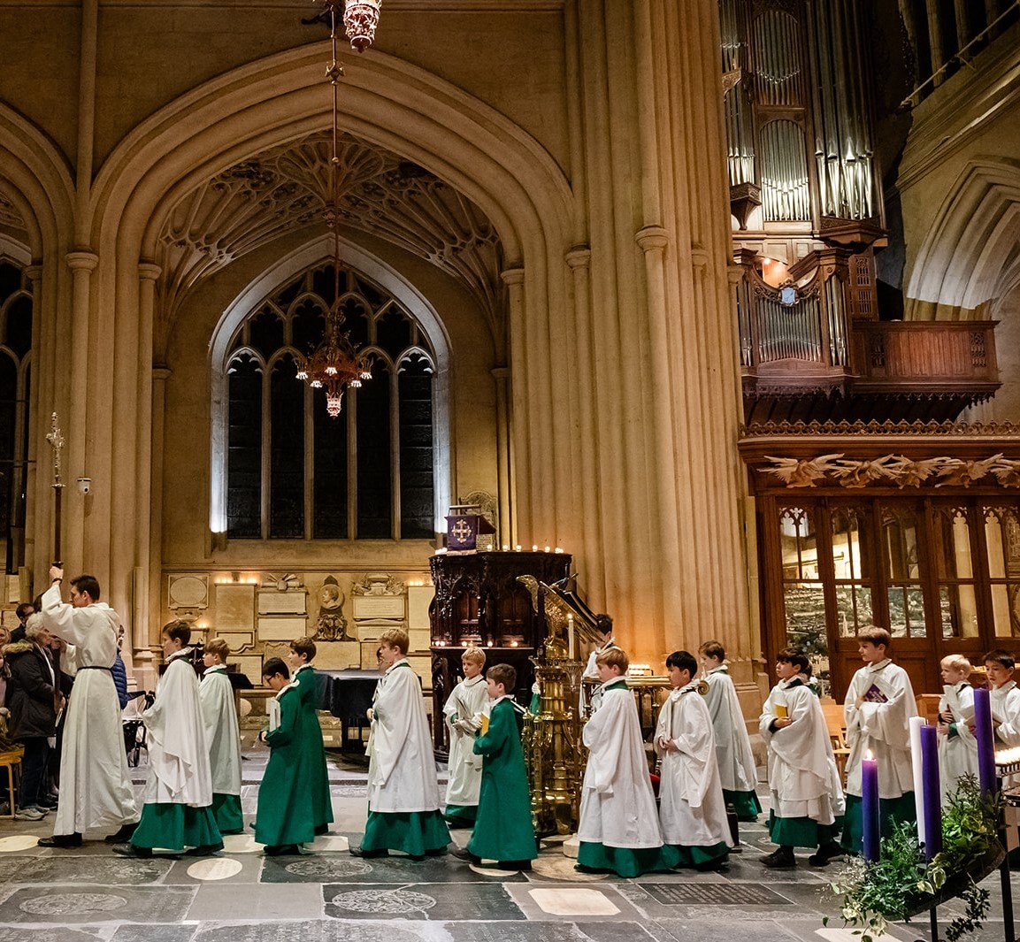 Robed choir boys process along the Nave of Bath Abbey