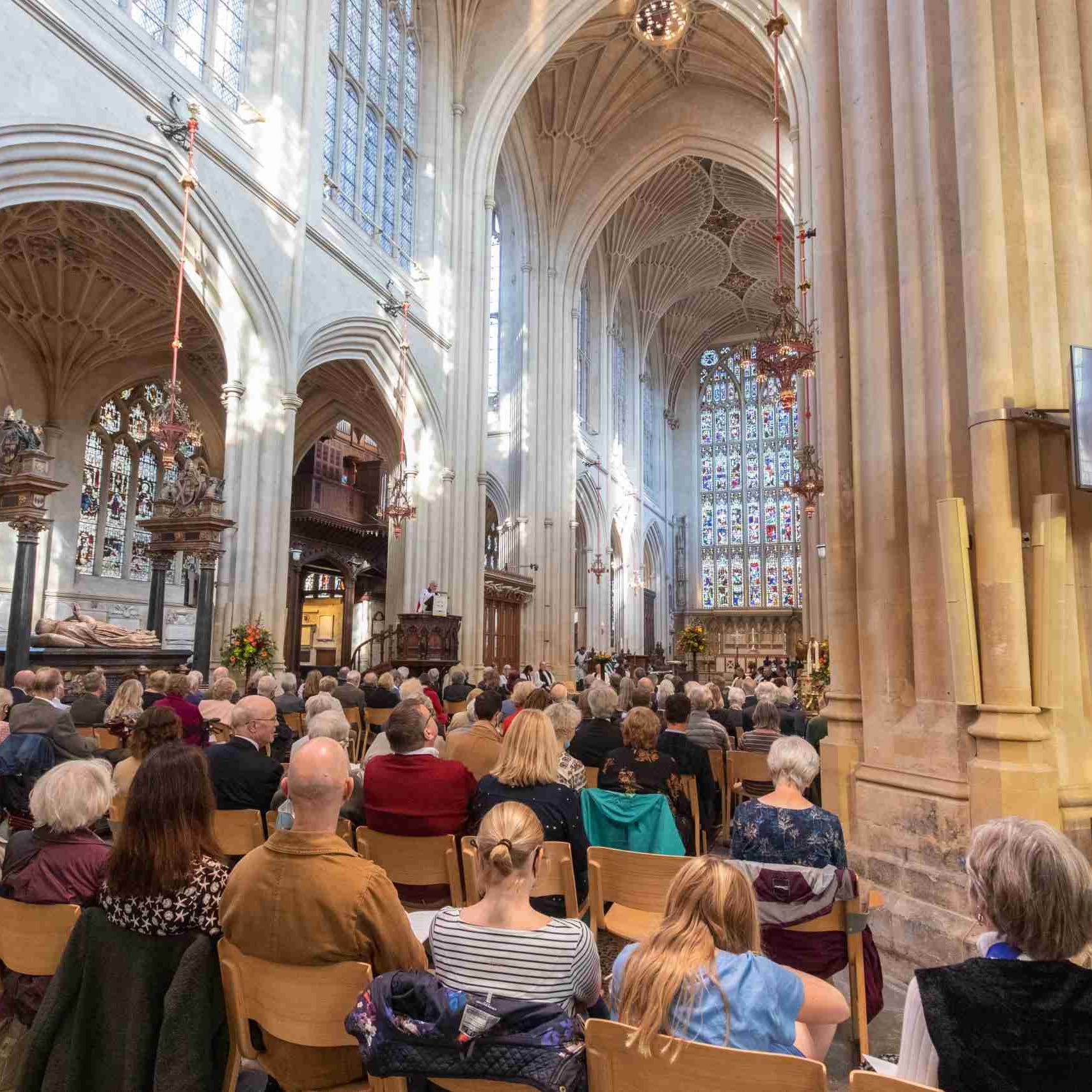 People sat in Bath Abbey listening to a service